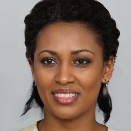 Joyful black young-adult female with long  black hair and brown eyes