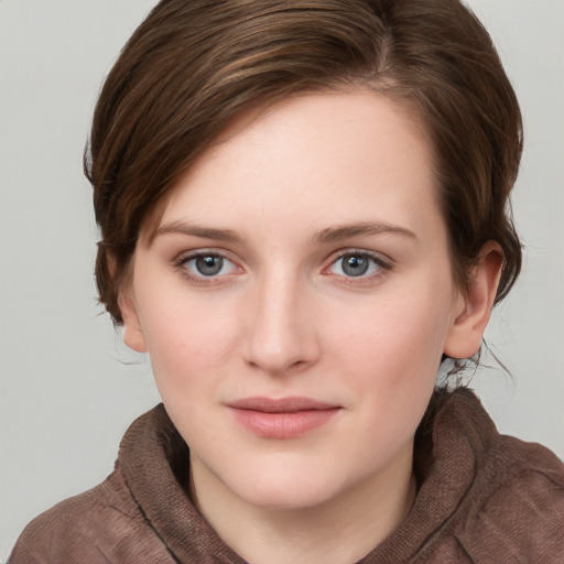 Joyful white young-adult female with short  brown hair and blue eyes