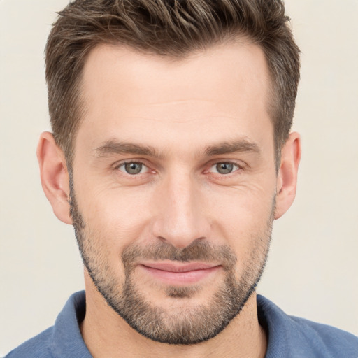 Joyful white young-adult male with short  brown hair and grey eyes