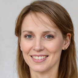 Joyful white young-adult female with long  brown hair and grey eyes