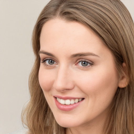 Joyful white young-adult female with long  brown hair and grey eyes