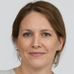 Joyful white adult female with medium  brown hair and grey eyes