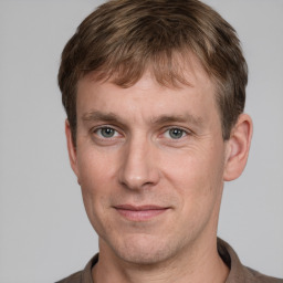 Joyful white adult male with short  brown hair and grey eyes