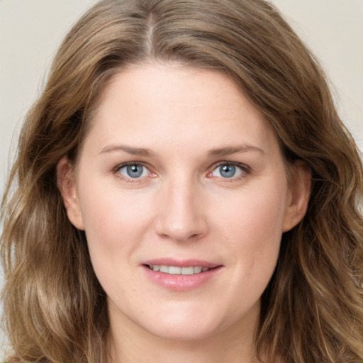 Joyful white young-adult female with long  brown hair and green eyes