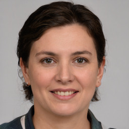 Joyful white adult female with medium  brown hair and grey eyes