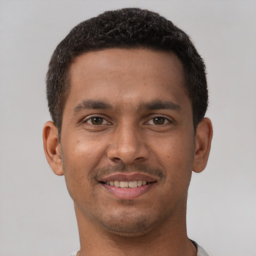 Joyful latino young-adult male with short  brown hair and brown eyes