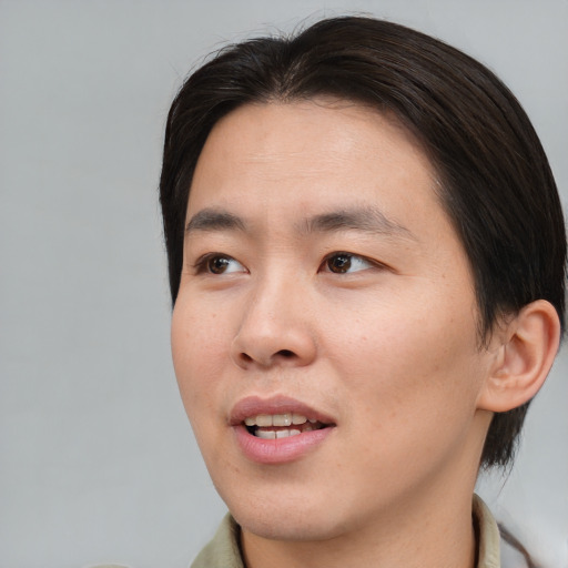 Joyful asian young-adult male with short  brown hair and brown eyes