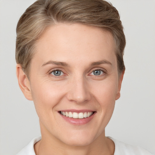 Joyful white young-adult female with short  brown hair and grey eyes