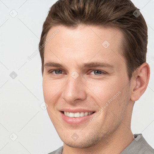 Joyful white young-adult male with short  brown hair and grey eyes