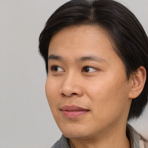 Joyful asian young-adult male with medium  brown hair and brown eyes