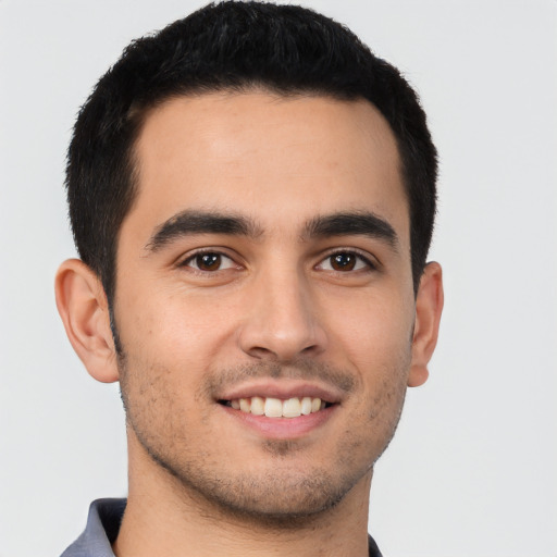 Joyful latino young-adult male with short  brown hair and brown eyes