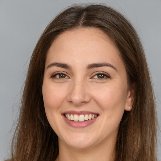 Joyful white adult female with long  brown hair and brown eyes