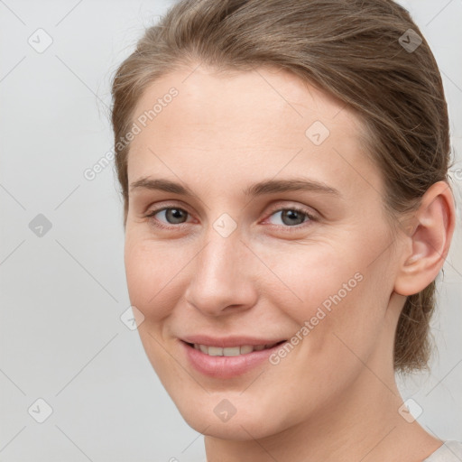 Joyful white young-adult female with medium  brown hair and grey eyes