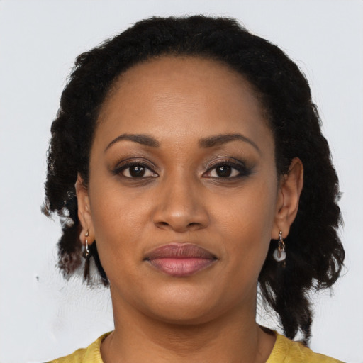 Joyful black young-adult female with long  black hair and brown eyes