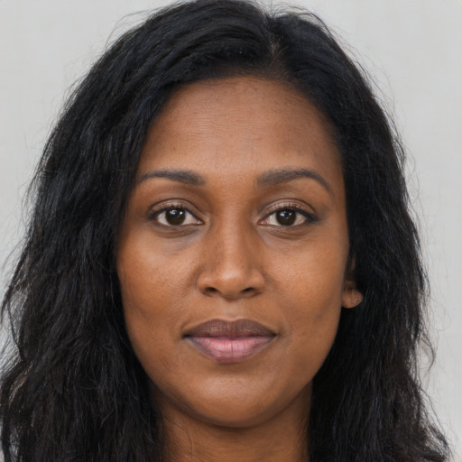 Joyful black young-adult female with long  brown hair and brown eyes