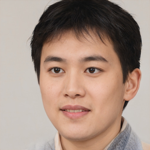 Joyful asian young-adult male with short  brown hair and brown eyes