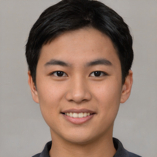 Joyful asian young-adult male with short  black hair and brown eyes