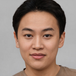 Joyful asian young-adult male with short  black hair and brown eyes