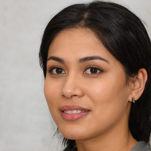 Joyful latino young-adult female with medium  black hair and brown eyes