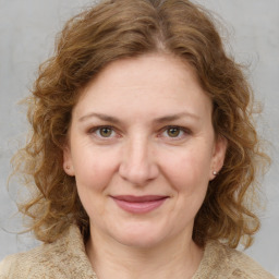 Joyful white adult female with medium  brown hair and blue eyes