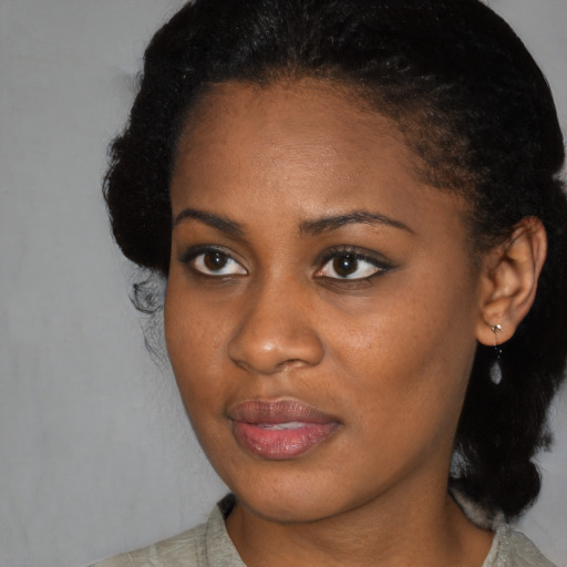 Joyful black young-adult female with medium  black hair and brown eyes