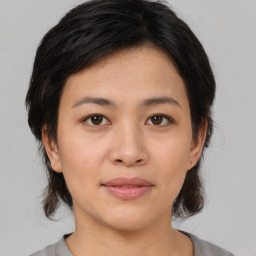 Joyful asian young-adult female with medium  brown hair and brown eyes