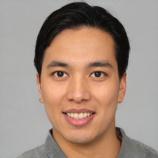 Joyful asian young-adult male with short  black hair and brown eyes