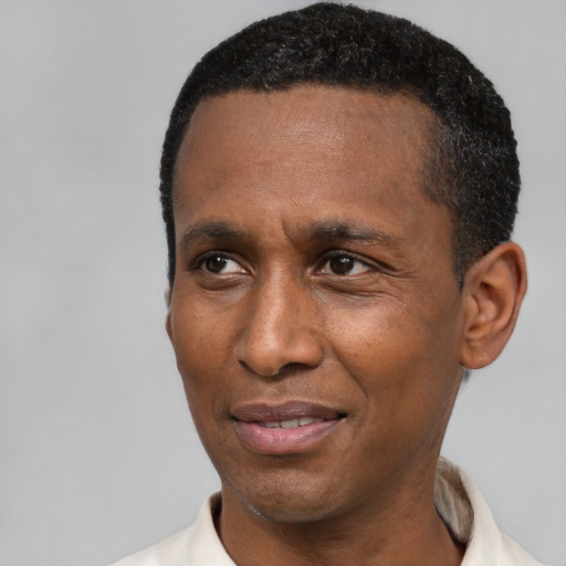 Joyful black adult male with short  black hair and brown eyes