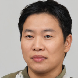 Joyful asian young-adult male with short  brown hair and brown eyes