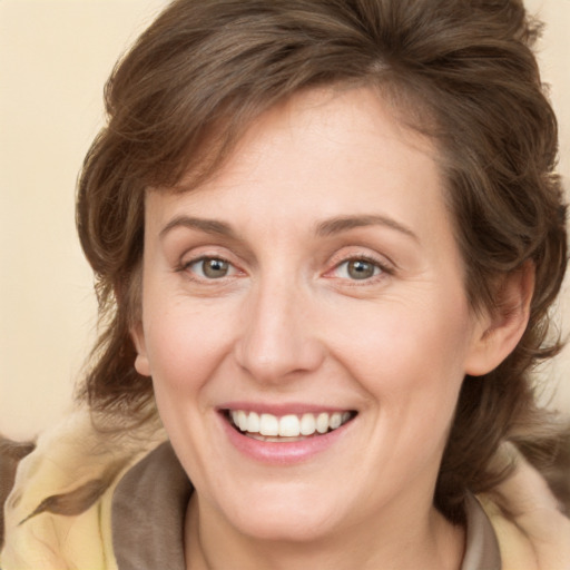 Joyful white young-adult female with medium  brown hair and green eyes