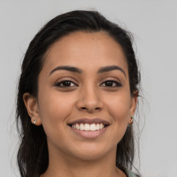 Joyful latino young-adult female with long  brown hair and brown eyes