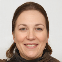 Joyful white adult female with long  brown hair and brown eyes