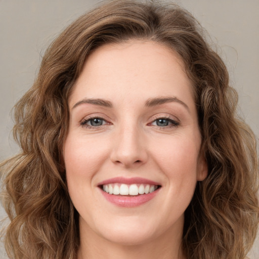 Joyful white young-adult female with long  brown hair and green eyes