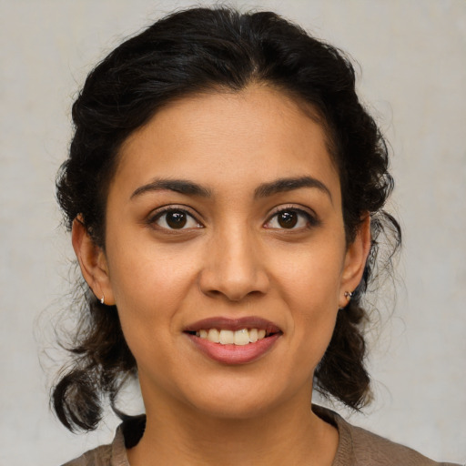 Joyful latino young-adult female with medium  brown hair and brown eyes