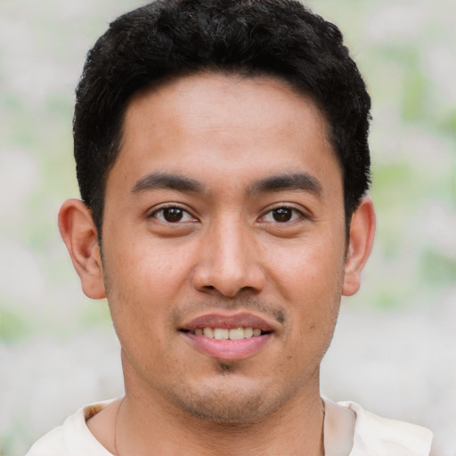 Joyful latino young-adult male with short  black hair and brown eyes