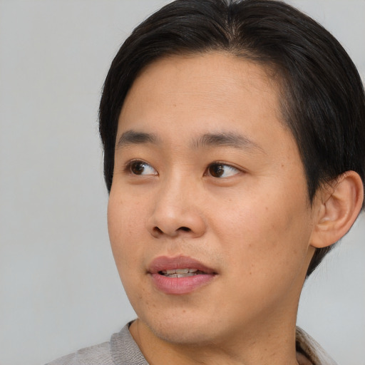 Joyful asian young-adult male with short  black hair and brown eyes