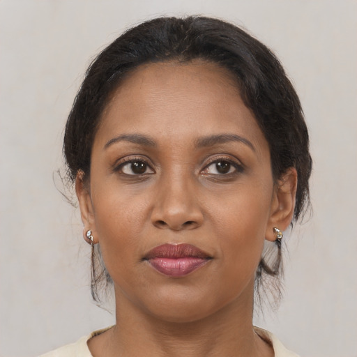Joyful black adult female with medium  brown hair and brown eyes