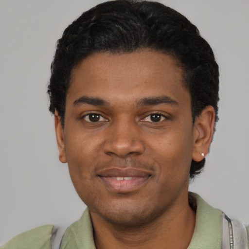 Joyful black young-adult male with short  black hair and brown eyes