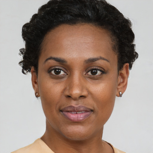 Joyful black young-adult female with short  black hair and brown eyes