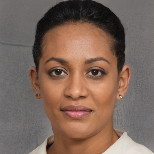 Joyful black young-adult female with short  black hair and brown eyes