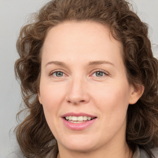 Joyful white young-adult female with medium  brown hair and green eyes