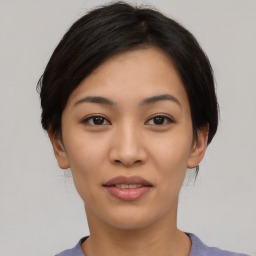 Joyful asian young-adult female with short  black hair and brown eyes