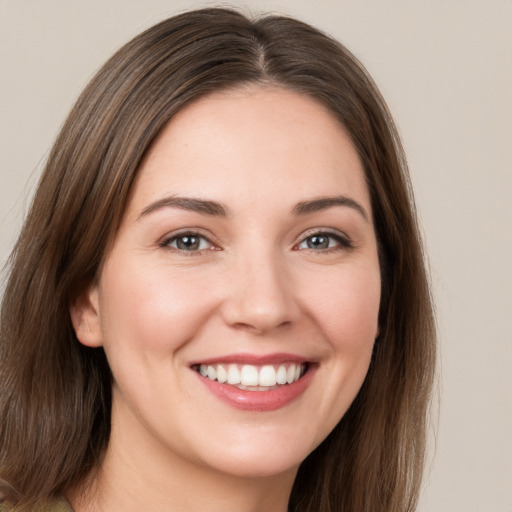 Joyful white young-adult female with long  brown hair and brown eyes