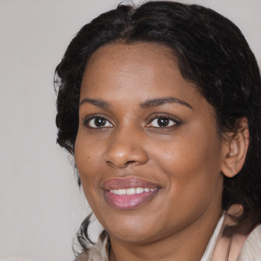 Joyful black adult female with medium  black hair and brown eyes