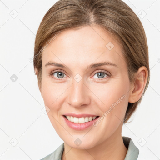 Joyful white young-adult female with medium  brown hair and grey eyes