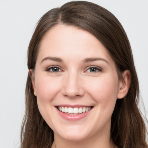 Joyful white young-adult female with long  brown hair and grey eyes