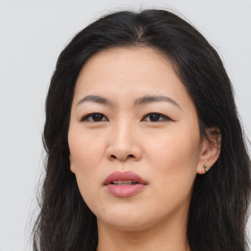 Joyful asian young-adult female with long  brown hair and brown eyes