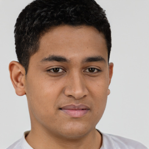 Joyful latino young-adult male with short  brown hair and brown eyes