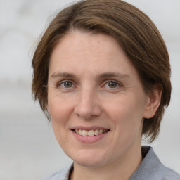 Joyful white adult female with medium  brown hair and grey eyes