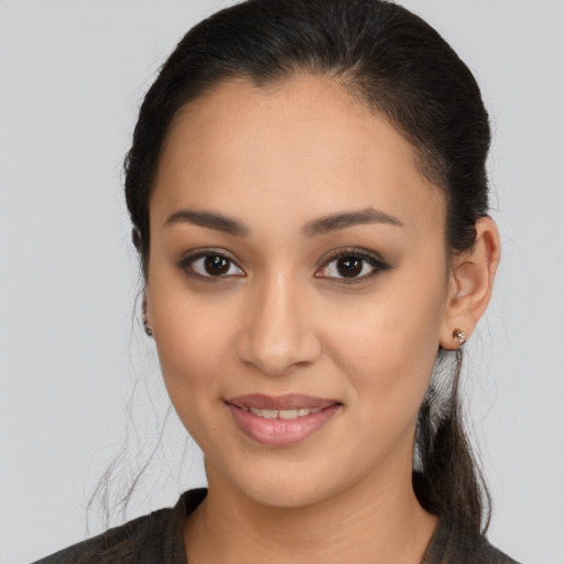 Joyful latino young-adult female with long  brown hair and brown eyes
